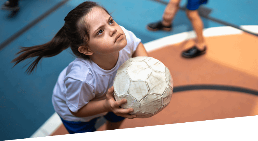 Young girl focused on target with football in hands ready to throw